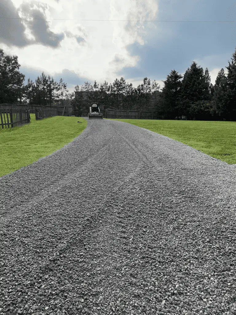 Do Trees Attract Lightning? What Raleigh Homeowners Should Know 4 Fonvilletreeservice crew operating skid steer to grade fresh gray gravel driveway between green lawns in NC