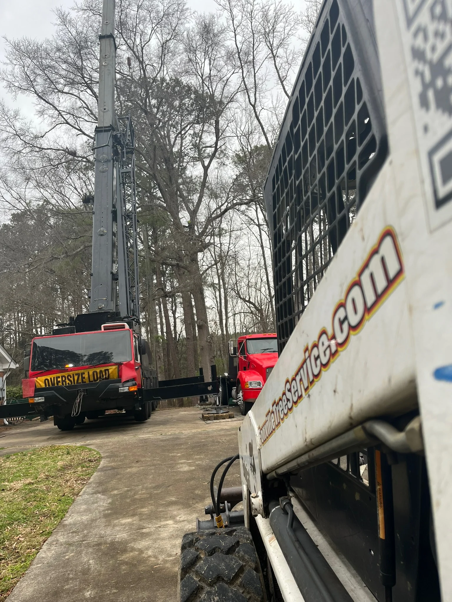 Fonvilletreeservice crane truck and skid steer equipment staged on residential driveway for tree service work in NC.