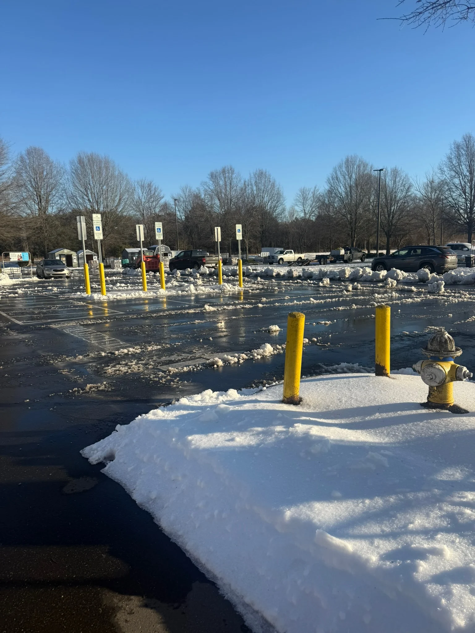 Home 21 Fonvilletreeservice winter parking lot scene with snow piles yellow bollards and fire hydrant after clearing in NC
