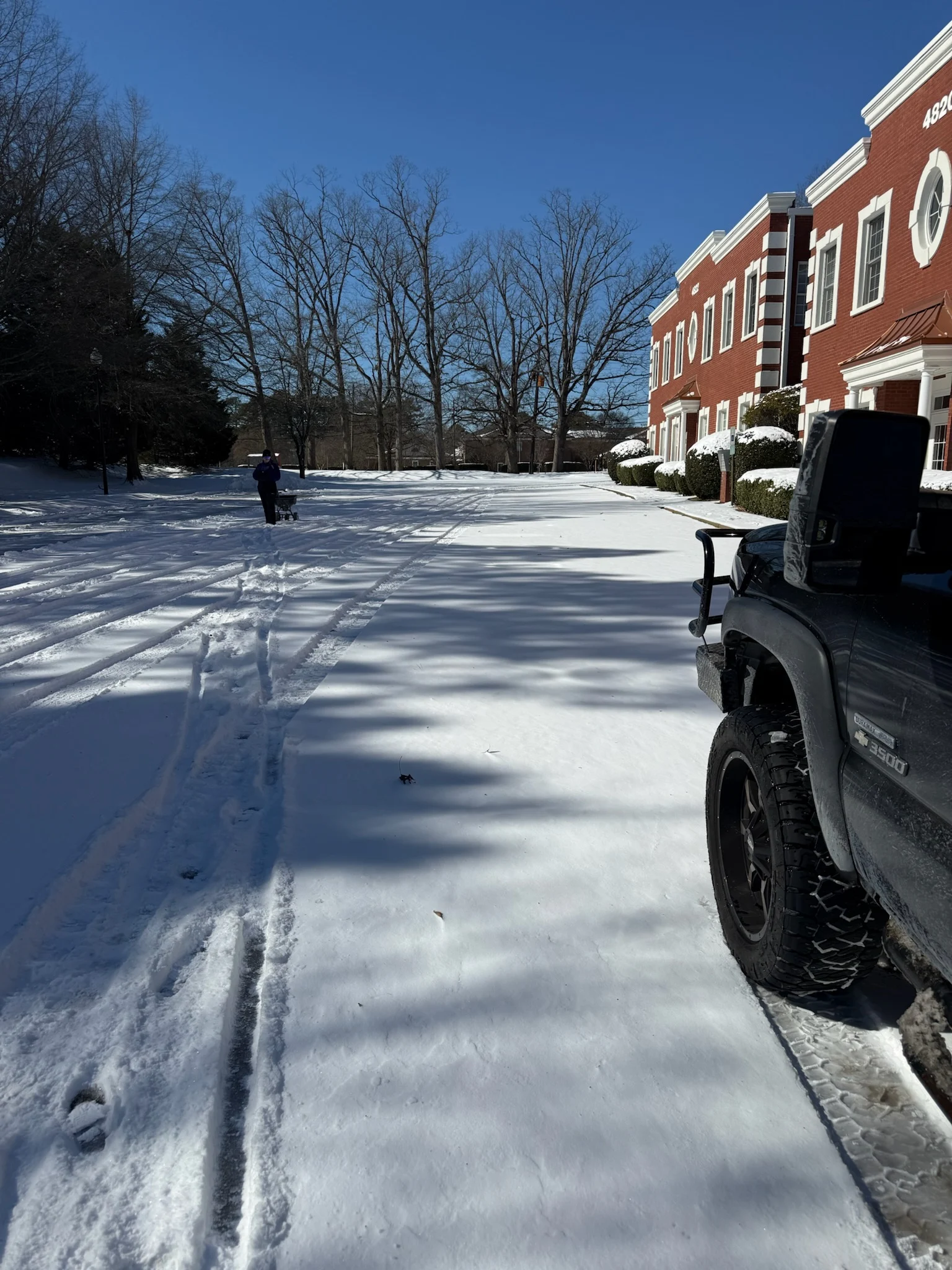 Home 23 Fonvilletreeservice crew member operating snow removal equipment to clear commercial parking lot after winter storm in NC